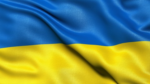 Das Bild zeigt einen faltenwerfenden Ausschnitt der ukrainischen Landesflagge. Sie besteht aus zwei Querstreifen. Der obere Streifen ist blau, der untere gelb.