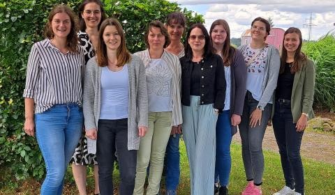 Neun Frauen nebeneinander stehend