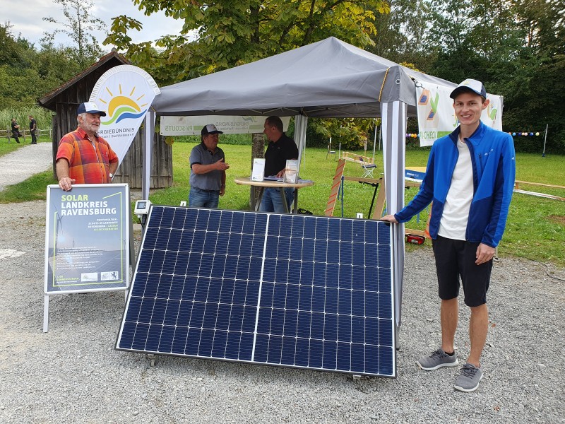 Ein Mann steht neben einer Photovoltaik-Anlage