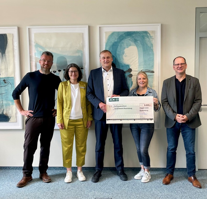 Scheckübergabe Personen der AOK überreichen einen Scheck an Vertreter des Landkreises